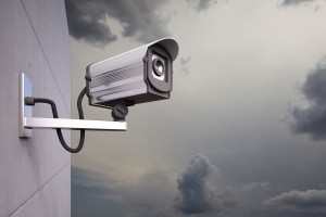 CCTV Camera attached to wall with clouds