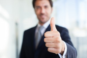 Portrait of a smiling businessman giving thumbs up